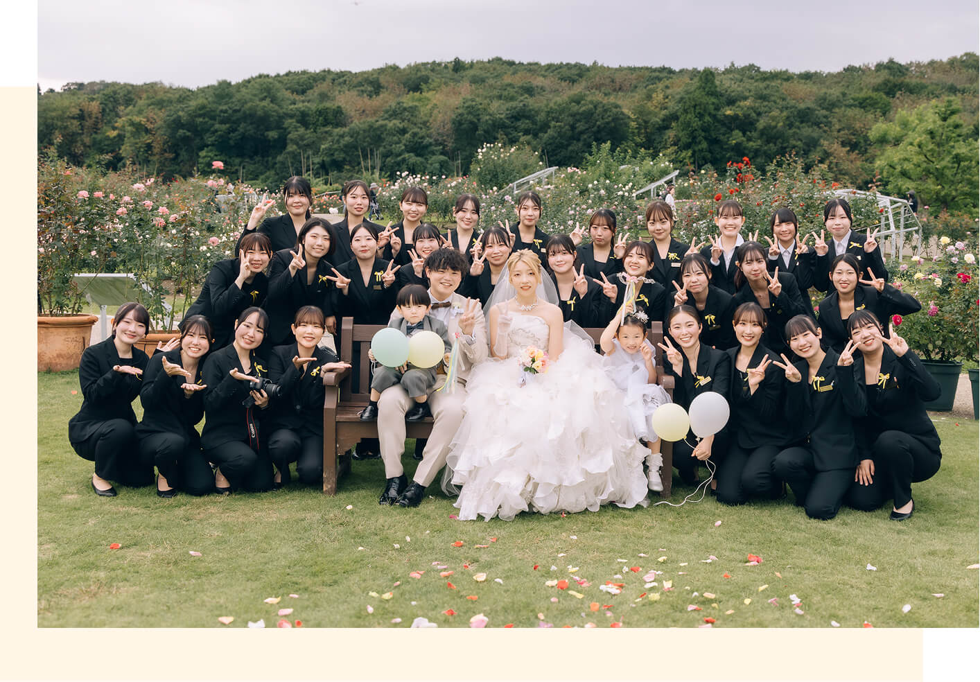 ローズガーデンで新郎新婦を囲む学生たち